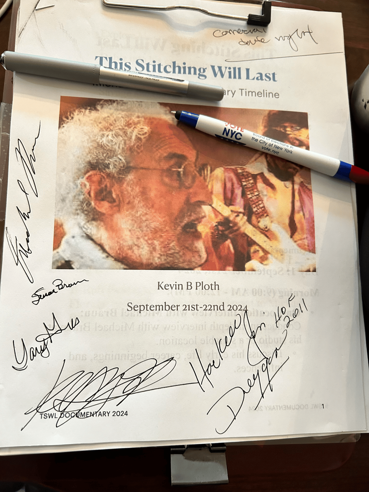 Signed This Stitching Will Last documentary page with an older man’s portrait, film details, handwritten autographs, and a pen