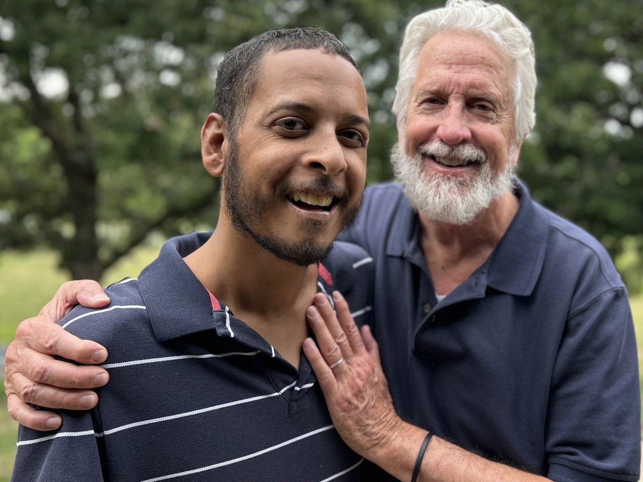Two Men Embrace Outdoors